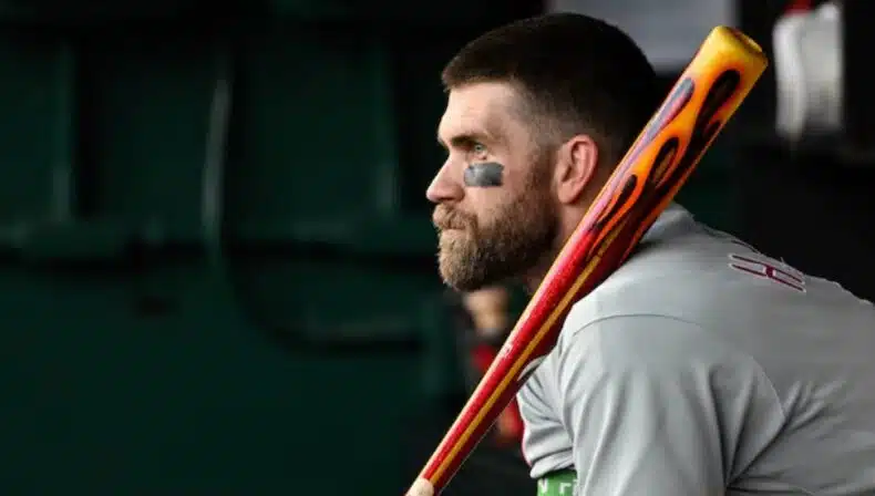 Bryce Harper sits in the dugout with his Victus Sports custom bat.