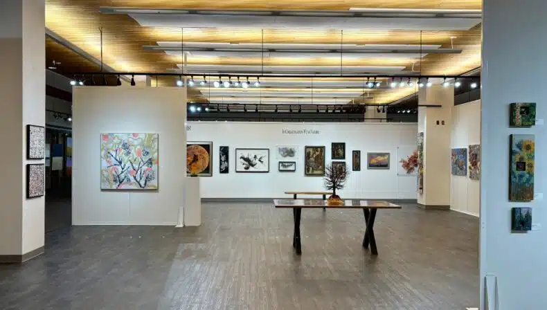 Wide view of the Lancaster Art Vault gallery showcasing colorful abstract paintings and modern sculptures under soft lighting.