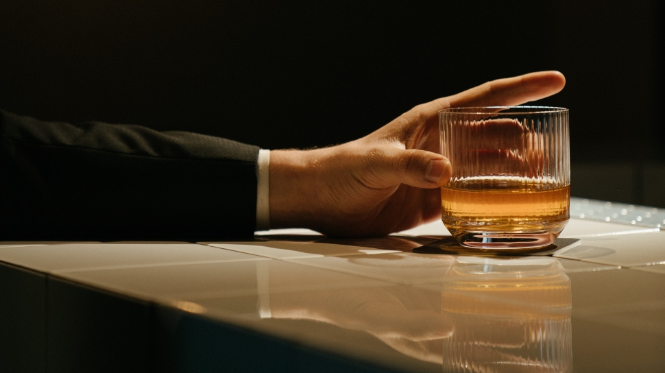 person drinking glass of whiskey