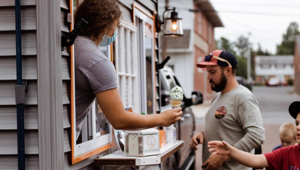 woman serving ice cream to boy