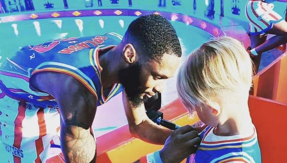 Harlem Globetrotter Mark Blount signs a fan's jersey.