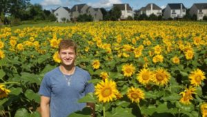Blake Gunter standing in his Sunflower Field