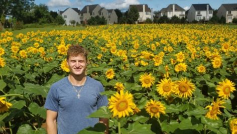 Blake Gunter standing in his Sunflower Field