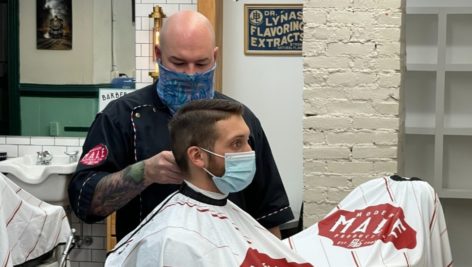 barber cutting man's hair.