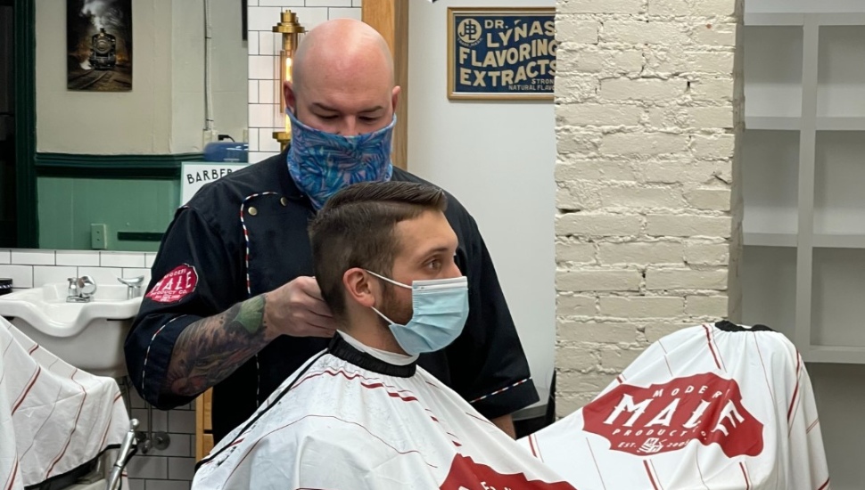 barber cutting man's hair.
