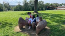 kids sitting on a rock reading