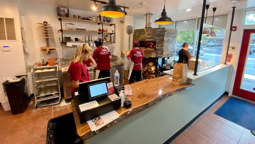 Staff at Terra Nova Woodfired Pizza & Grill working on a Hawaiian Pizza