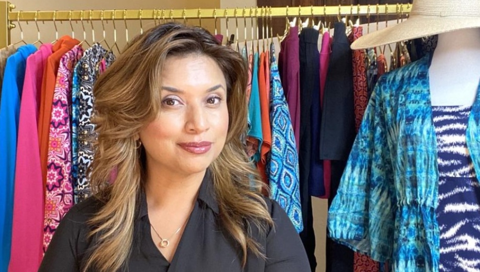 woman in front of rack of clothes