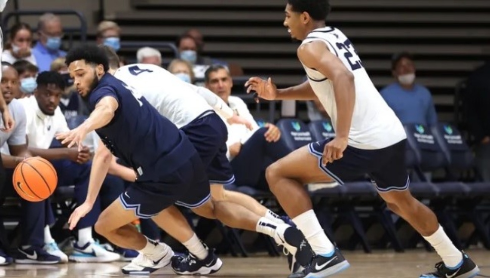 Caleb Daniels (left) dives for a loose ball in front of Jermaine Samuels during an Oct. 7 basketball game.