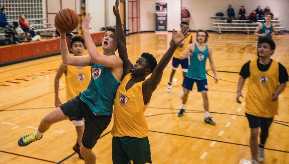 Boys playing basketball in high school.