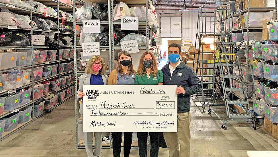 masked presenters of a large check