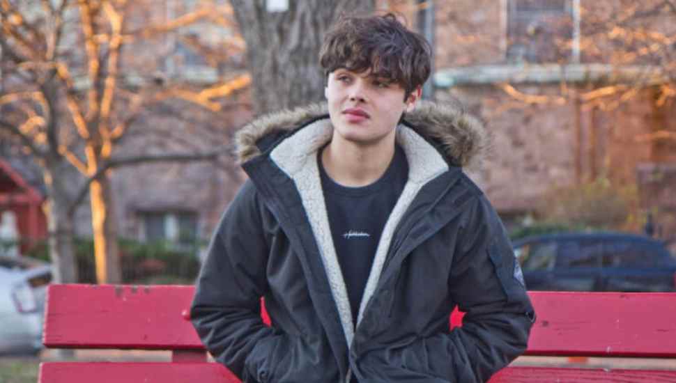 teenager in jacket on a red bench