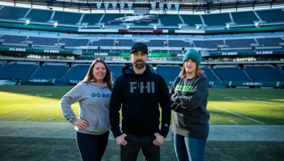 two women, one man in a stadium