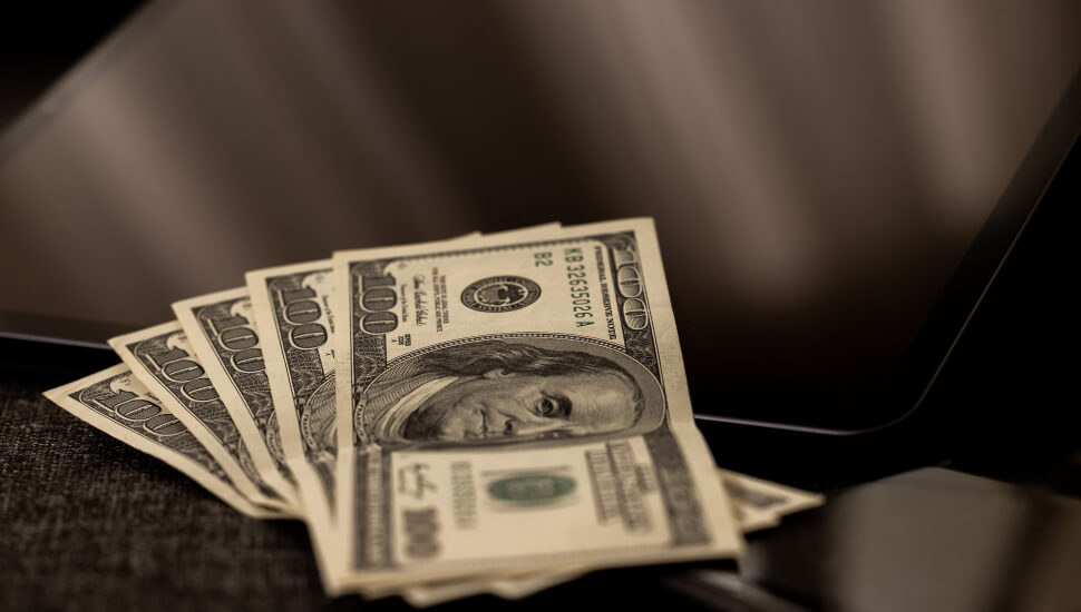 $500 Bills laid out on a laptop