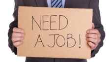 Man holding need a job sign.