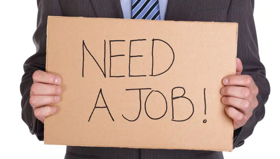Man holding need a job sign.