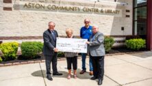 Chris Domes, Nancy Bowden, Fred Prendergast and Les Berry holding a big check for Camp Rainbow.