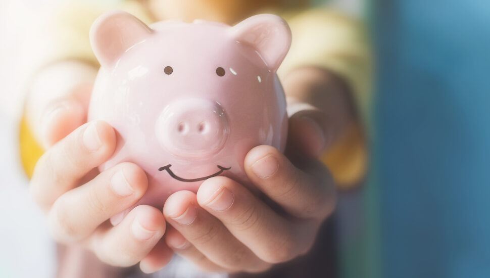 Child hand holding piggy bank