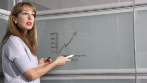 Woman presenting in front of a white board