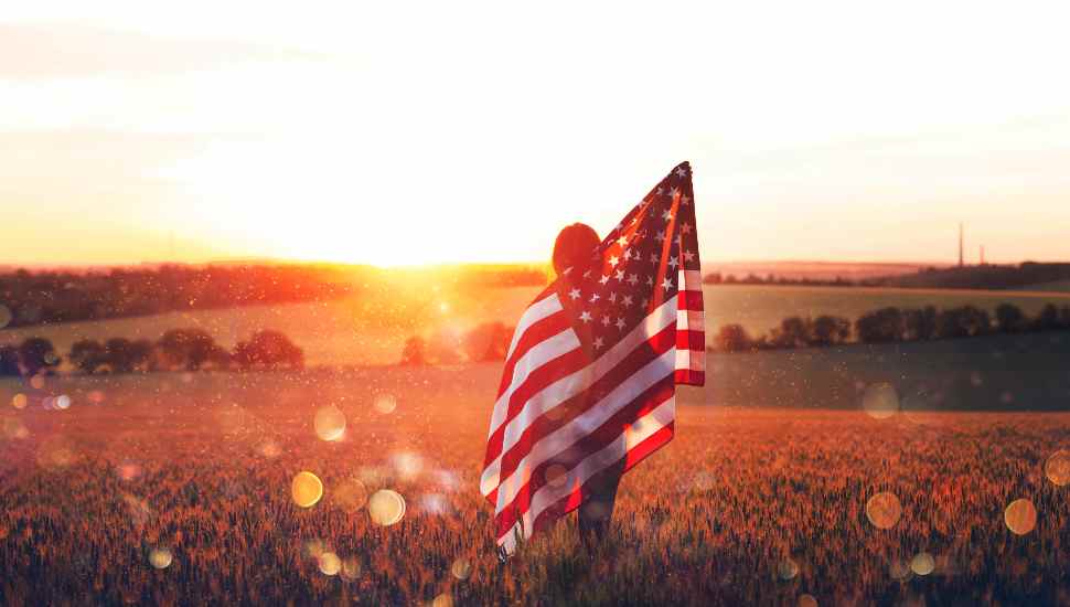 woman in field with flag