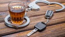 An alcoholic beverage, car keys and a pair of handcuffs.