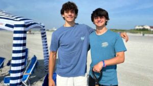 two teens side by side on a beach