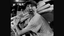 Max Patkin clowning around holding multiple baseball bats