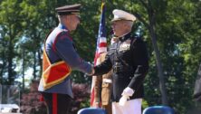 A Valley Forge Military College Cadet shakes hands with a college official.