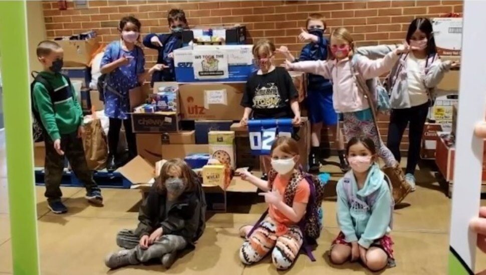 Children in masks with donated food