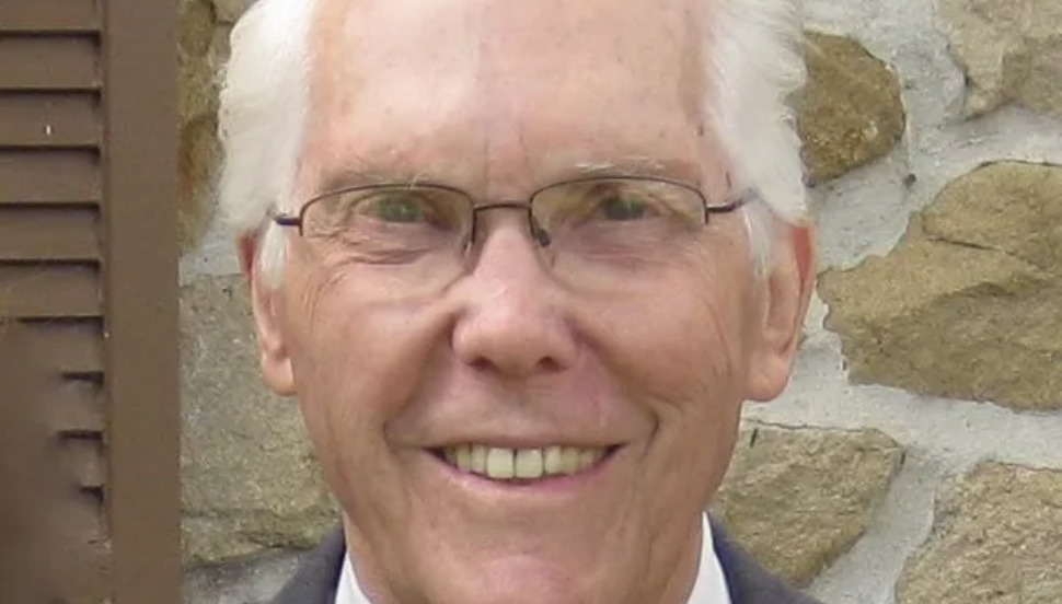 man with white hair and glasses