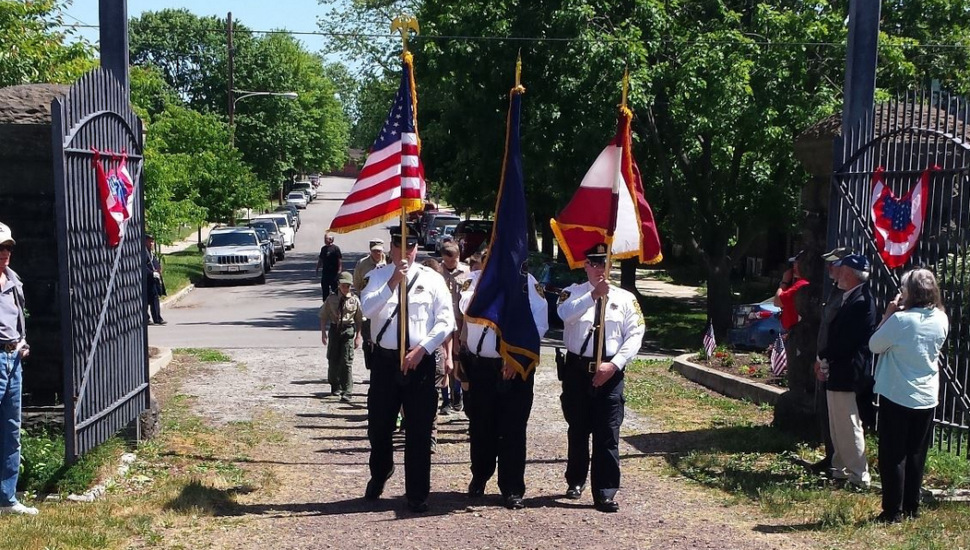 men carrying flags through a gate