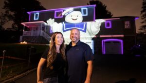 Jen and John DiMeo pose with the Stay Puft Marshmallow Man projected on their Monster House