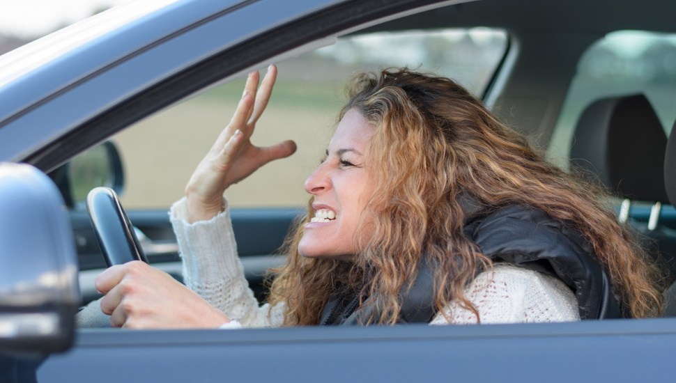 aggravated woman behind the wheel of a car