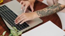 High angle shot of modern young womans hands typing something on laptop