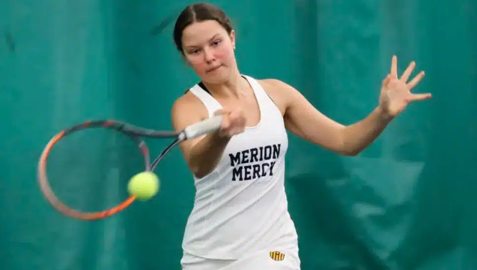 girl hitting tennis ball