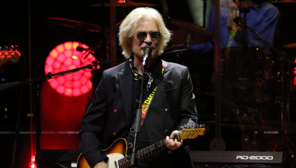 man with white hair playing guitar