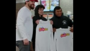 Kyle Schwarber poses with fans holding SchwarberFest T-shirts at a Wawa store.