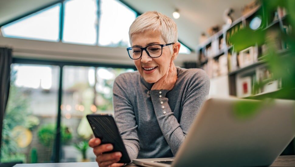 businesswoman using smart phone at home office, working remotely