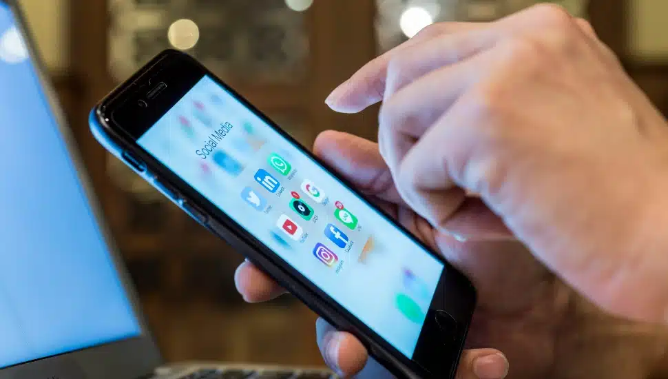 a man selecting LinkedIn on his smart phone