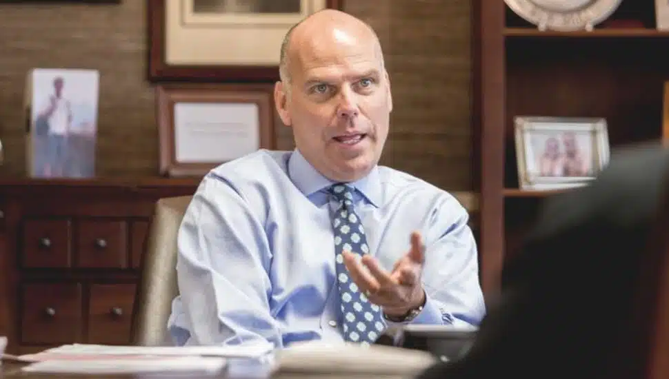 man in shirt and tie behind desk