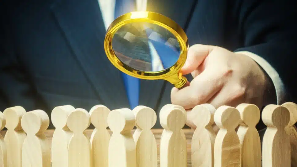 man with magnifying glass eyeing the 2023 job market