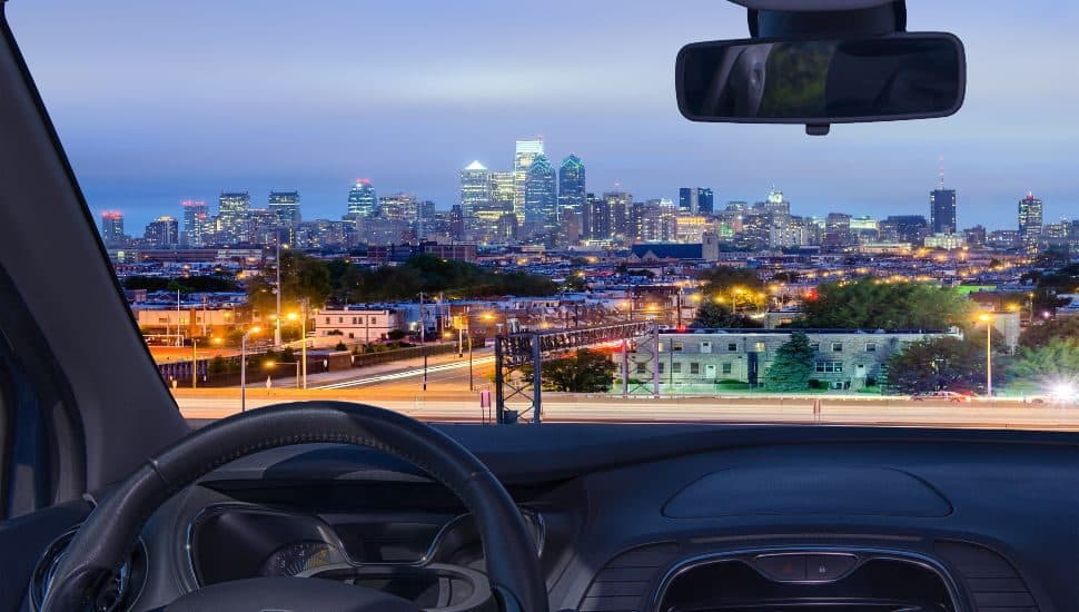 Looking through a car windshield with view of Philadelphia skyline at night