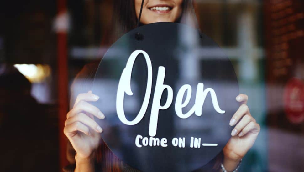 woman with sign in a new restaurant