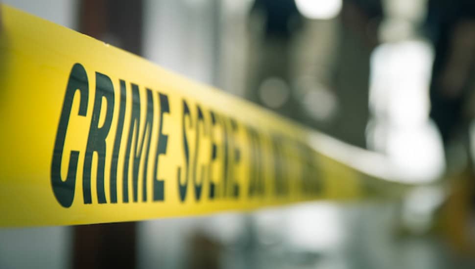 crime scene tape with blurred forensic law enforcement background in cinematic tone and copy space