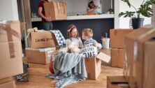 Two kids playing in boxes as their parents move into a new house