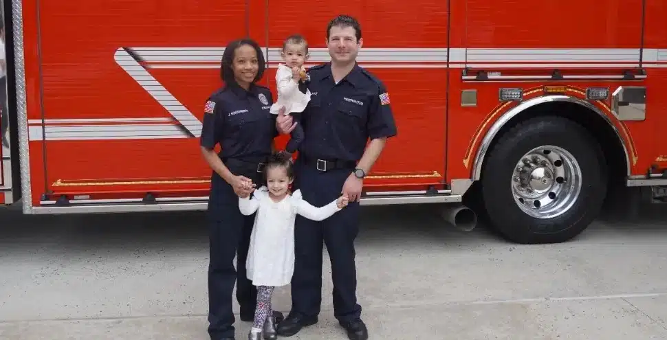 Jennifer Kingsberry, with her husband and two young daughters in front of fire truck