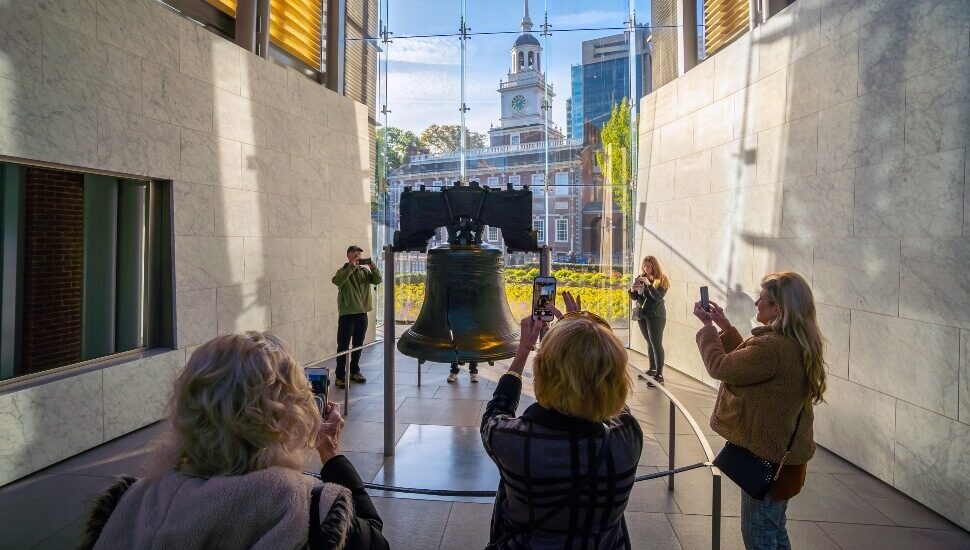 Tourist snapping pictures of the Liberty Bell.