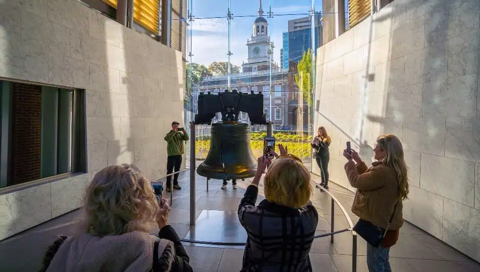 Tourist snapping pictures of the Liberty Bell.