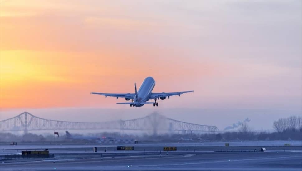 An airline plane lifting off from Philadelphia International Airport around sunset