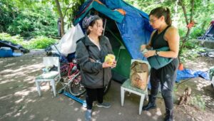 Draya LaMacchia (left) speaks with homeless advocate Sephanie Sena at a homeless. encampment in Norristown.